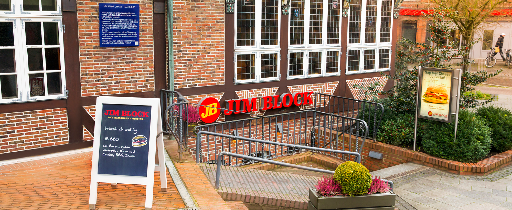 Eingang zum Jim Block Restaurant in Bergedorf mit Fachwerkfassade und Aufstelltafel.